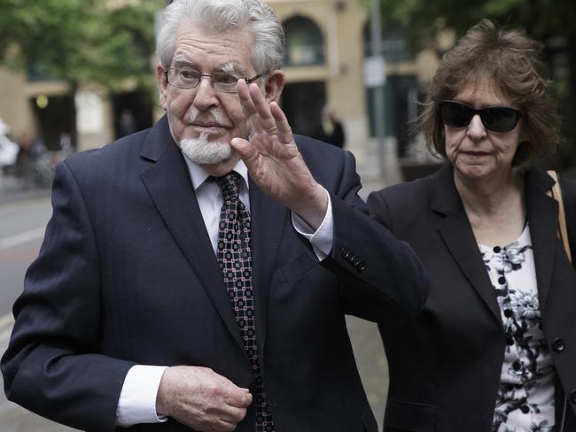 Rolf Harris, left, waves as he arrives at Southwark Crown Court with his niece Jenny Harris. Picture: AP Photo/Tim Ireland