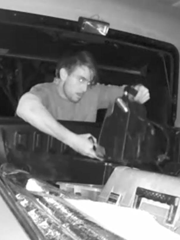 The man uses a torch to cherry pick his loot before stealing a battery charger.