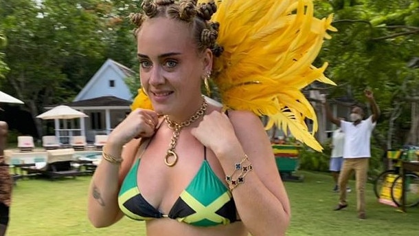 Adele has woken up the woke cancellists for styling her hair in African bantu knots and wearing a bikini top in the colours of the Jamaican flag.