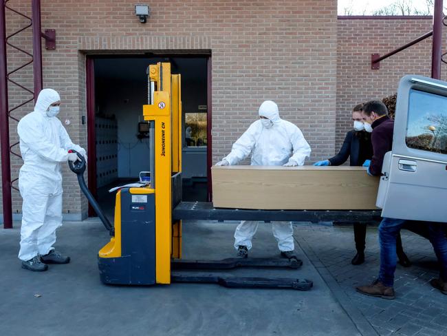 Workers carry a coffin in the cremation of coronavirus victim at the Wilrijk crematory in Antwerp, Belgium. Picture: AFP