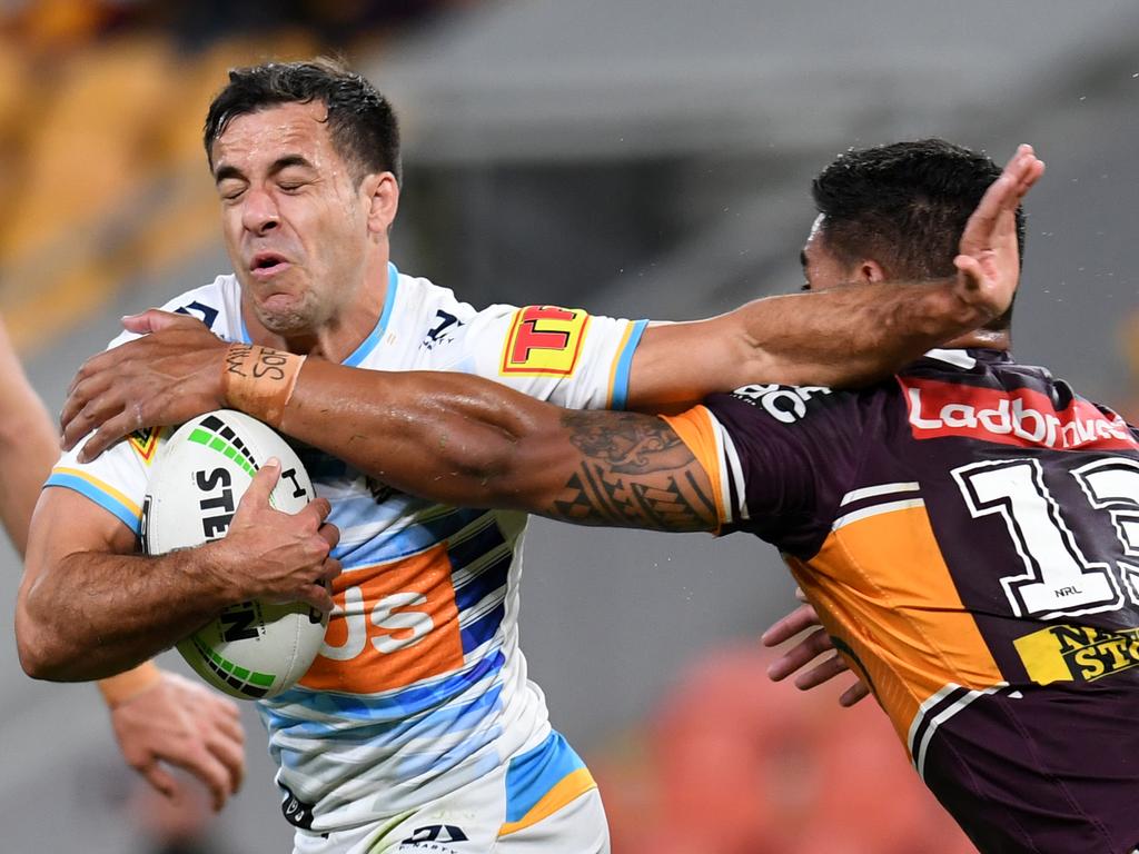 Thompson fends off Joe Ofahengaue in his second game as a Titan. (AAP Image/Dan Peled)