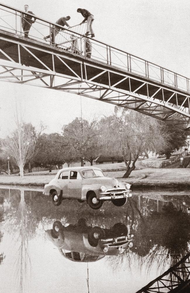 An FJ Holden dangles from a city bridge over the River Torrens in 1971, in one of the most infamous Prosh Day pranks in Adelaide’s history.