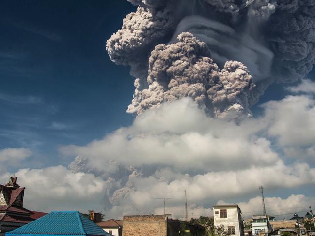 Sinabung sent ash and smoke 5,000 metres into the air, leaving local villages coated in debris and officials scrambling to hand out face masks. Picture: AFP
