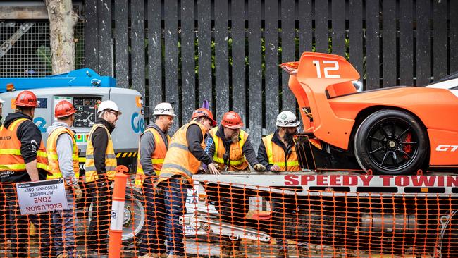 Workers securing the fancy car before the big haul. Picture: Jake Nowakowski