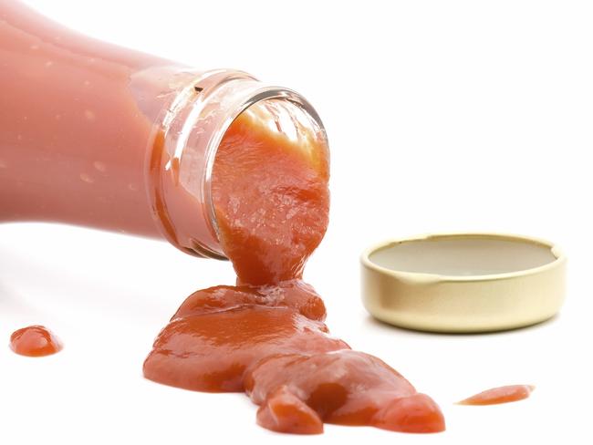 ketchup spilling from open bottle studio isolated