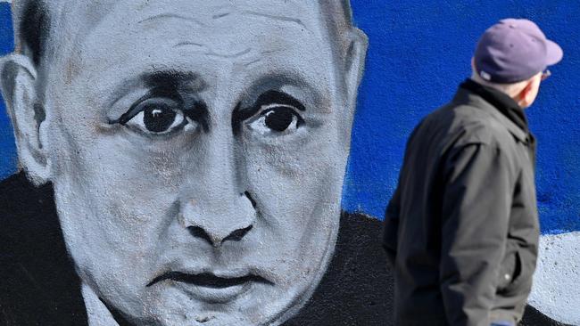 A man walks past a mural depicting Russian President Vladimir Putin, with the Russian flag, in Belgrade. Picture: Andrej Isakovic/AFP