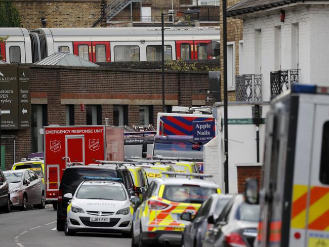 A train, on which a homemade bomb exploded, stands above parked police vehicles on a road below at Parsons Green subway station in South West London last Friday. Picture: AP