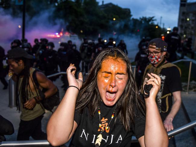 A woman reacts after being sprayed by pepper spray next to the Colorado State Capitol. Picture: Michael Ciaglo