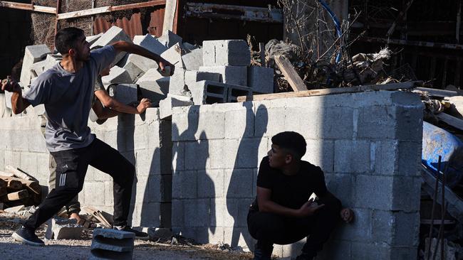 Palestinian youths throw stones towards Israeli forces as soldiers conduct a search operation in Baita village in the disputed West Bank. Picture: AFP