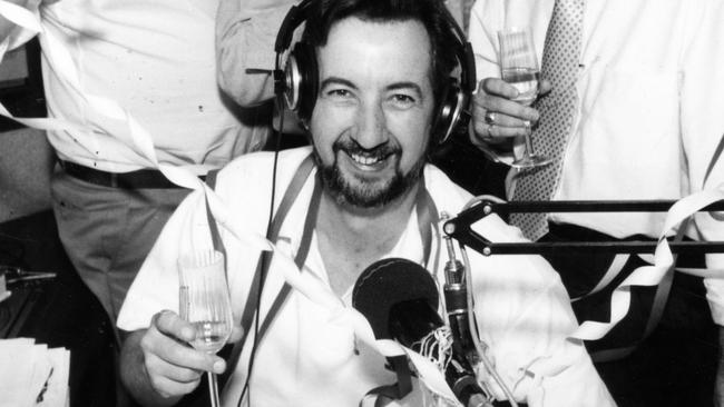 5AD radio announcer John Dean (front) sitting at desk in radio station, celebrating ratings win with colleagues (back l-r) Jeff Sunderland, Jeremy Cordeaux and Wayne Clouten, 26 Feb 1993.