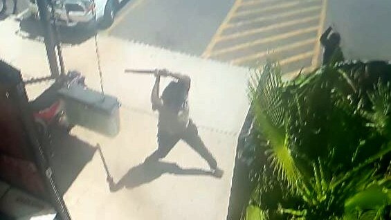 A group of a dozen men and women engage in conflict brandishing weapons - including machetes and baseball bats - outside The Gap View Hotel in Alice Springs just in September, 2022.