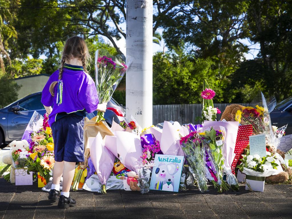 A child looks at the growing floral tributes at the scene of the tragedy. Picture: Nigel Hallett