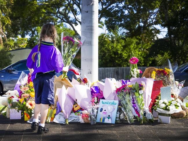 A child looks at the growing floral tributes at the scene of the tragedy. Picture: Nigel Hallett