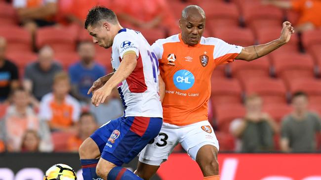 Brisbane Roar’s Henrique (right) is challenged by Newcastle’s Wayne Brown on Saturday night.