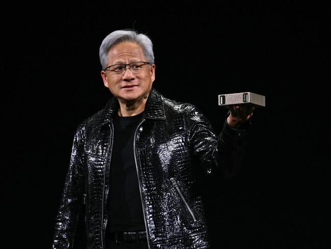 Nvidia CEO Jensen Huang holds a personal AI supercomputer during a keynote address at the Consumer Electronics Show (CES) in Las Vegas, Nevada on January 6, 2025. Gadgets, robots and vehicles imbued with artificial intelligence will once again vie for attention at the Consumer Electronics Show, as vendors behind the scenes will seek ways to deal with tariffs threatened by US President-elect Donald Trump. The annual Consumer Electronics Show (CES) opens formally in Las Vegas on January 7, 2025, but preceding days are packed with product announcements. (Photo by Patrick T. Fallon / AFP)