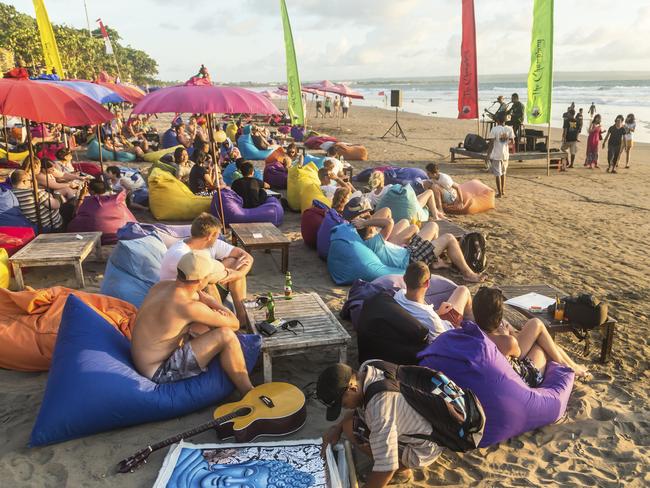 Bali’s beach bars are a magnet for tourists. Pictured, drinking on Seminyak beach before sunset.