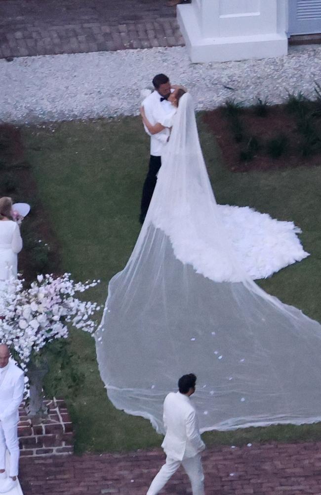 Jennifer Lopez wears a stunning white wedding dress as she celebrates her marriage to Ben Affleck, suitably dashing in a white jacket and black pants. Picture: BACKGRID Australia