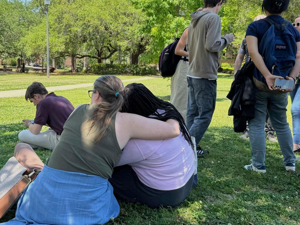 People comfort each other on Florida State University’s campus in Tallahassee as police respond to the shooting. Picture: AP