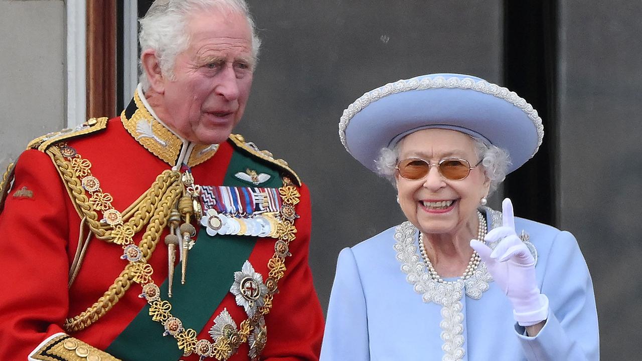 Queen Elizabeth II stands with Prince Charles, Prince of Wales to watch a special fly-past from Buckingham Palace balcony. (Photo by Daniel LEAL / AFP)