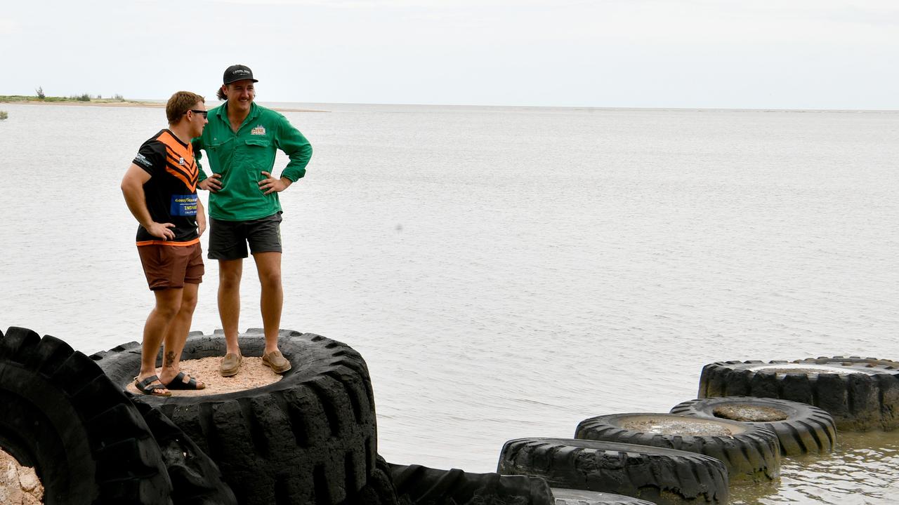 Brothers Jacob and Jhi Poletti take a break from helping clean up their grandmother's home near the waterfront at Cungulla. Picture: Evan Morgan