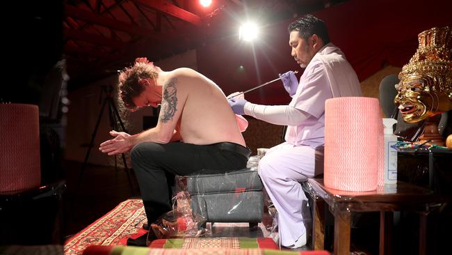 <i>Invisible House</i> curator Brendan Walls gets a Sak Yant tattoo from Ajarn Ohr at the Salamanca Arts Centre. Picture: SAM ROSEWARNE