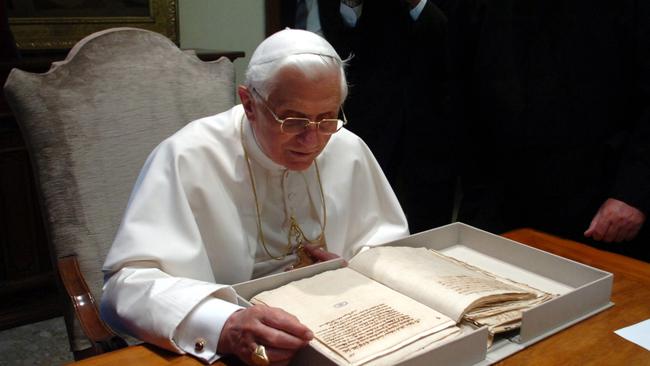 Benedict XVI leafs through a book of documents of the trial of Italian astronomer Galileo Galilei (1564-1642), part of the collection of books of the Vatican library, during his visit to the Vatican's secret archives in 2007. Picture: L'Osservatore Romano / AP