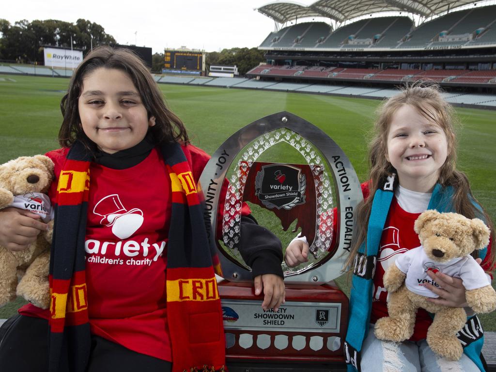 Jesem Hayal, 10 and Elsie McBride, 5 with the Showdown trophy that will be awarded for the first time when Adelaide and Port Adelaide clash on Thursday. Picture: Brett Hartwig