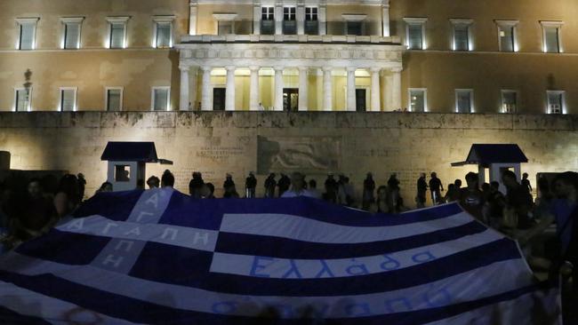 Anti-austerity protesters shown holding a Greek flag reading ''Greece we love you''. Things got ugly after that though.