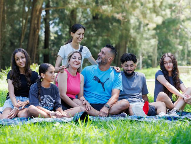 Zabaiullah Haidary and his wife Maryam with their children (from left) Freshta, 13, Pakeeza 11, Ellaha, 20, Haroun, 22, and Behishta, 16, in Penrith. Picture: David Swift