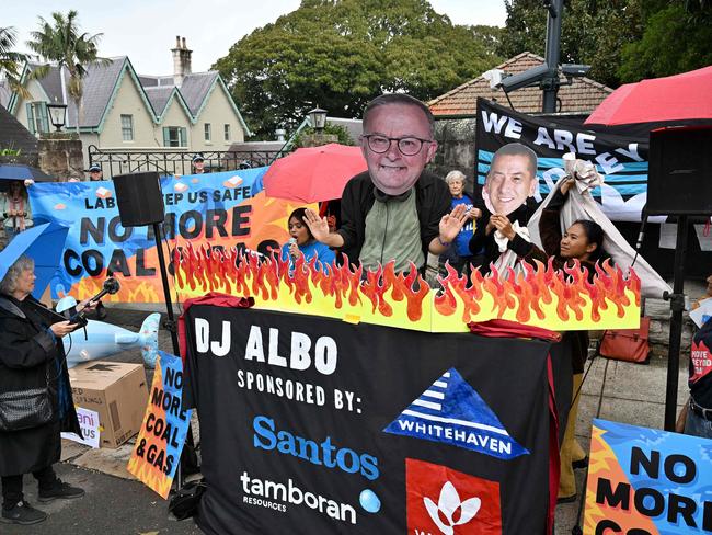 An environmental activist wearing a cardboard cutout of Prime Minister Anthony Albanese’s face outside Kirribilli House. Picture: Saeed KHAN / AFP)\