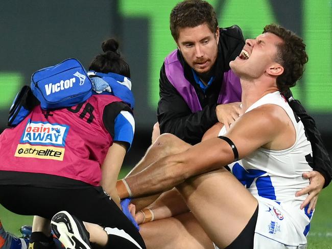 MELBOURNE, AUSTRALIA - APRIL 29: Charlie Comben of the Kangaroos is attended to by trainers during the round seven AFL match between Melbourne Demons and North Melbourne Kangaroos at Melbourne Cricket Ground, on April 29, 2023, in Melbourne, Australia. (Photo by Quinn Rooney/Getty Images)