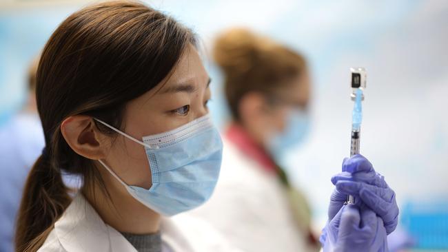 Technicians measure doses of the Pfizer vaccine for COVID-19 at the Virginia Hospital Centre in the US.