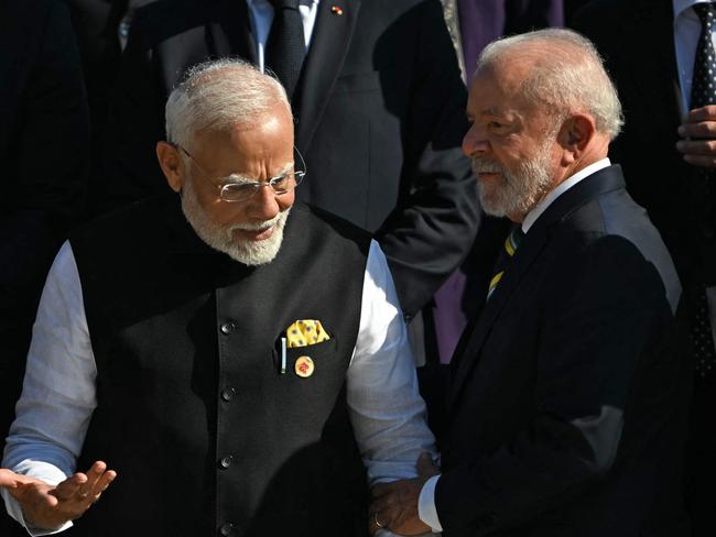 India's Prime Minister Narendra Modi (2nd L) speaks with Brazil's President Luiz Inacio Lula da Silva, amid (L to R clockwise) Turkey's President Recep Tayyip Erdogan, Argentina's President Javier Milei, France's President Emmanuel Macron, Germany's Chancellor Olaf Scholz and South Africaâs President Cyril Ramaphosa during a group photo at the end of the first session of the G20 Leaders' Meeting in Rio de Janeiro, Brazil, on November 18, 2024. (Photo by Mauro PIMENTEL / AFP)