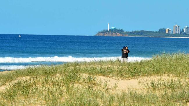 The search for a lost fisherman was called off after his body was recovered on the eastern side of Old Woman Island. Family and friends grieve on Mudjimba Beach. Picture: John McCutcheon