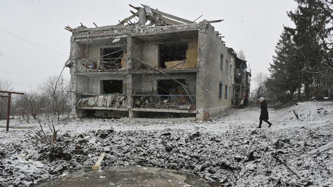 A local resident walks past a crater and a damaged residential building following a recent aerial bombardment in Kupiansk, Kharkiv region in Ukraine. Picture: AFP