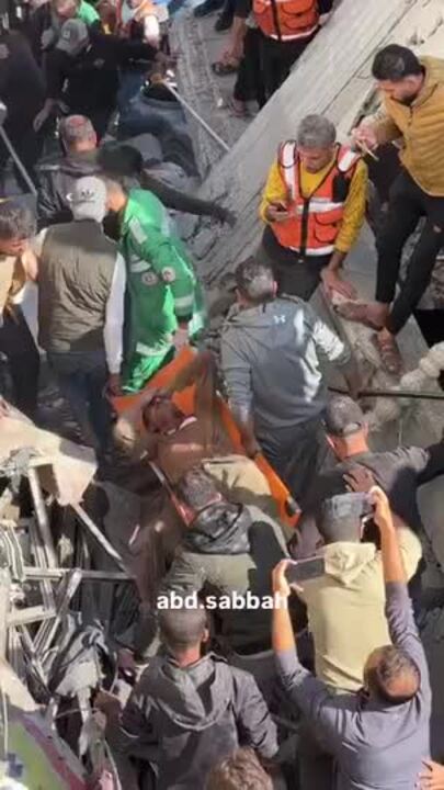 Crowd Looks On as Man Carried From Rubble in Gaza City