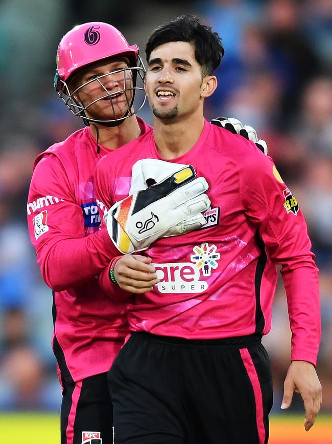 Izharulhaq Naveed is congratulated by Josh Philippe.