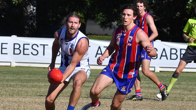 Mt Gravatt player Corey Mcguren gets a handball away. Picture, John Gass