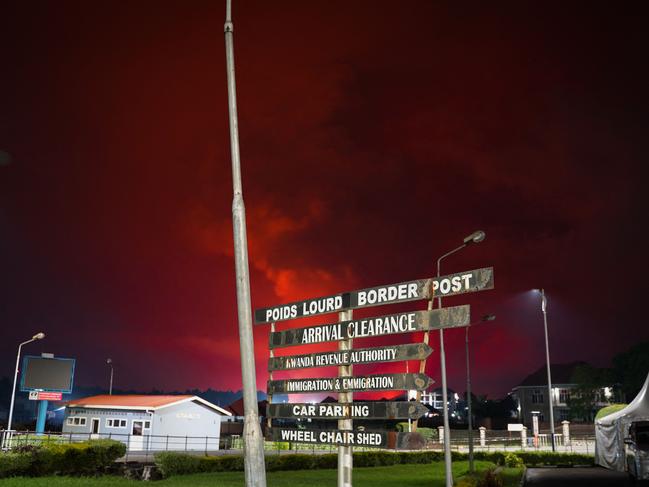 The red sky is seen after the Nyiragongo volcano erupted in the Democratic Republic of the Congo as seen from the border in Gisenyi, Rwanda, on May 23, 2021. - The government of the Democratic Republic of Congo has ordered the evacuation of the eastern city of Goma after the eruption of Mount Nyiragongo overlooking the border city. The lava reached the city's airport early Sunday, with an official from Virunga National Park -- where the volcano is located -- telling his staff: "the situation is deteriorating". (Photo by Simon Wohlfahrt / AFP)