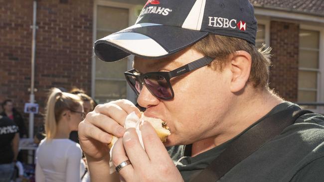 Stephen Oates loves his democracy sausage at Panania Public School. Picture: Matthew Vasilescu