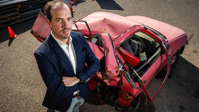 Ben with the crumpled wreck of the Mitsubishi Lancer. Picture: Tom Huntley