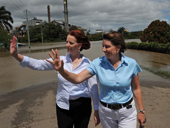 A helping hand ... Julia Gillard and Queensland Premier Anna Bligh wave to residents as they inspect a flooded neighbourhood in Bundaberg on December 31, 2010.