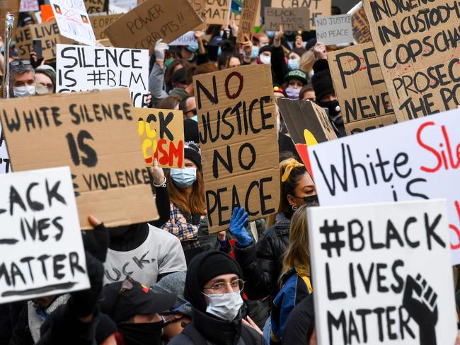 People hold up placards at a Black Lives Matter protest in Melbourne on Saturday. Picture: AFP