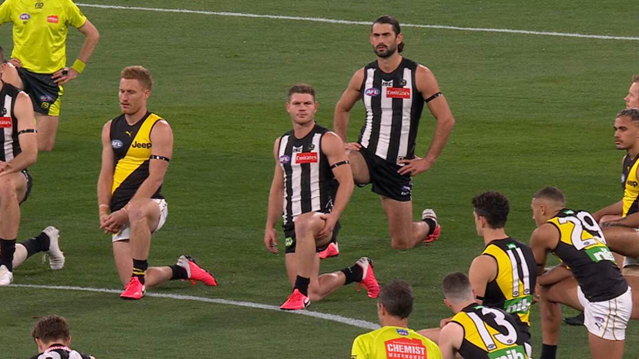 AFL players take a knee before the first bounce.