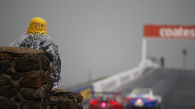 A boy watches cars in the rain on top of Mount Panorama during a previous Bathurst.