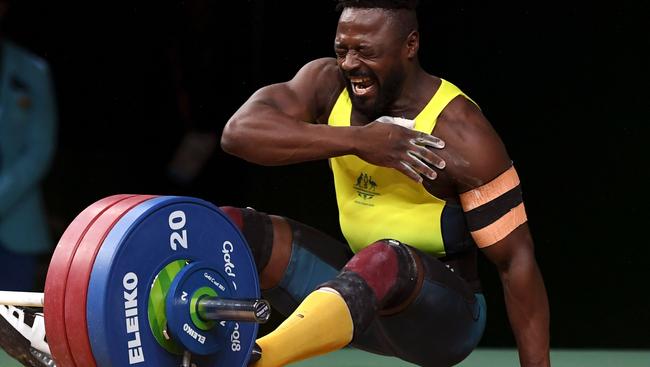 Francois Etoundi reacts as he injures his shoulder in the men's 77kg weightlifting. Picture: AFP/William West