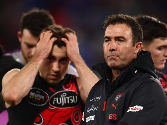MELBOURNE, AUSTRALIA - MAY 17: Andrew McGrath of the Bombers reacts as Brad Scott, Head Coach of the Bombers prepares to speak to players during the round ten AFL match between Western Bulldogs and Essendon Bombers at Marvel Stadium, on May 17, 2025, in Melbourne, Australia. (Photo by Morgan Hancock/Getty Images)