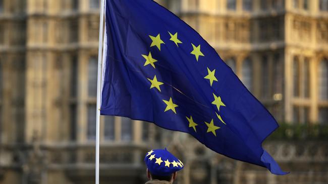 A pro-Europe demonstrator holds a flag outside the Houses of Parliament in London. Picture: AP. 