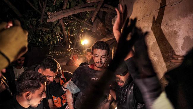 Palestinian civil defence and local residents evacuate a wounded man from the destroyed al-Qadri house which was struck by Israeli bombardment in Rafah.