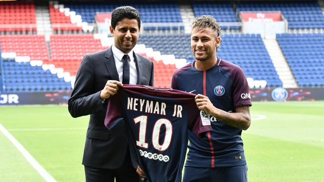 Brazilian superstar Neymar (R) poses with his jersey next to Paris Saint Germain's (PSG) Qatari president Nasser Al-Khelaifi.